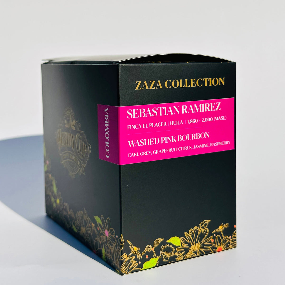A black Heady Cup Coffee Roasters Zaza Collection box of Colombia Coffee. Label is magenta and box is against a pink background. Earl grey, grapefruit citurs, jasmine, and raspberry is on the label. 