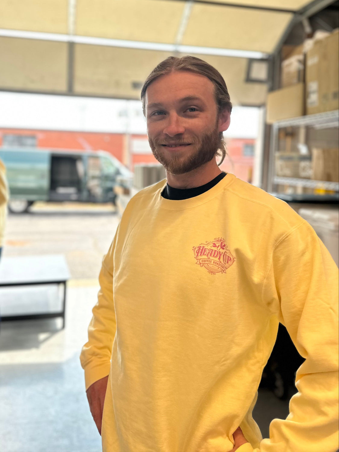 Jack wearing a yellow Heady Cup Coffee Roasters definition crewneck sweatshirt. 