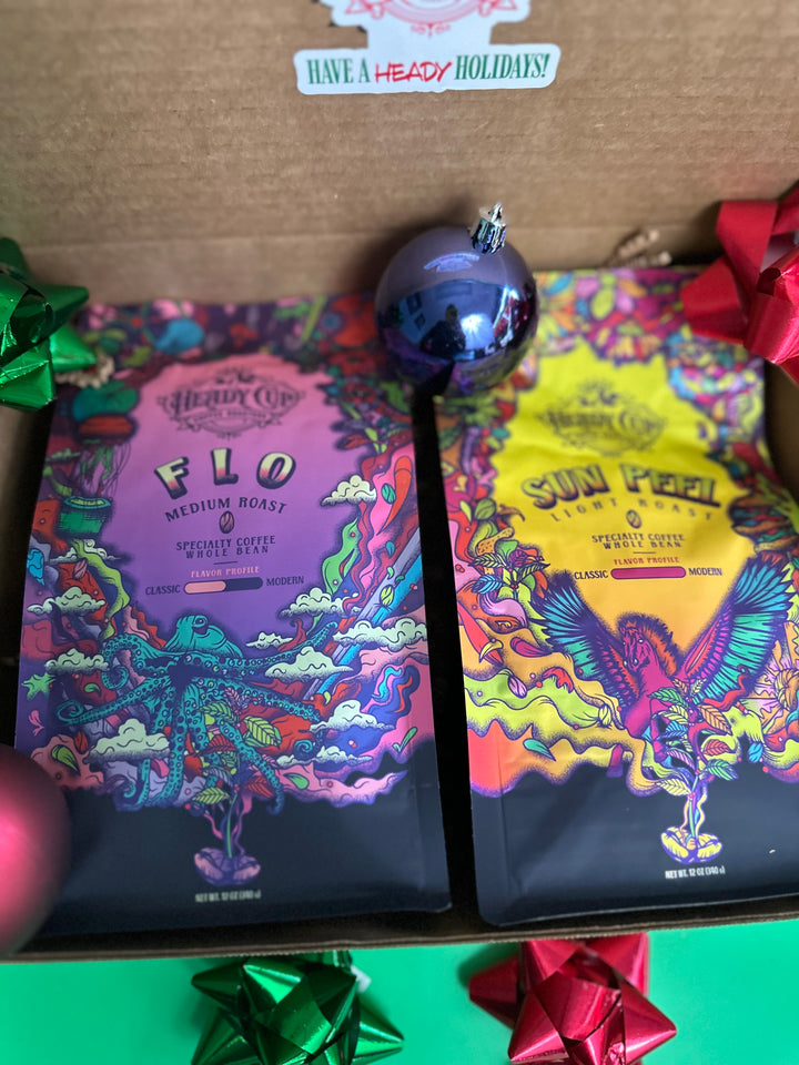 A picture of two colorful Heady Cup Coffee Roasters bags in a  two blend gift box
