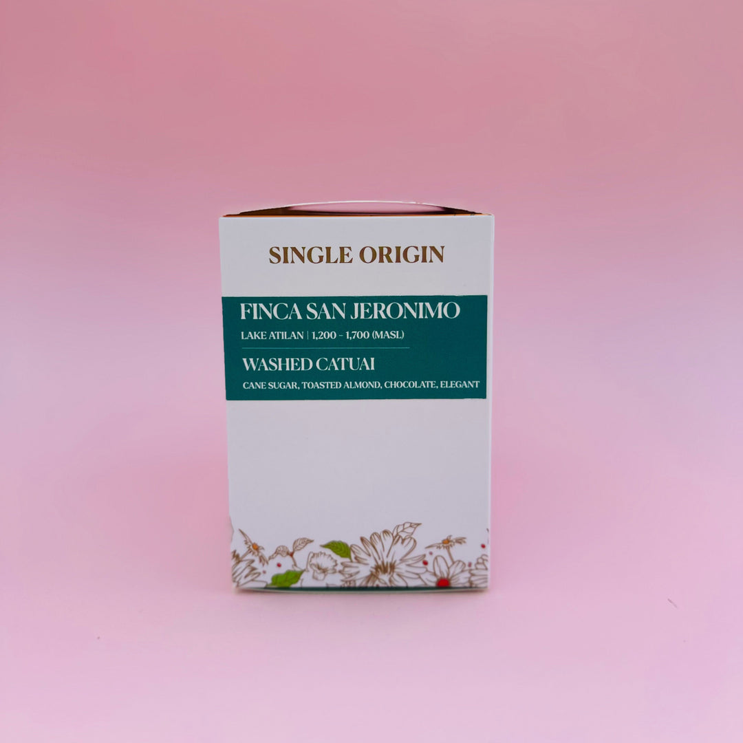 A single-origin Heady Cup Coffee Roasters box labeled FINCAS SAN JERONIMO, with washed catuai text and floral artwork near the bottom, standing upright on a soft pink background.