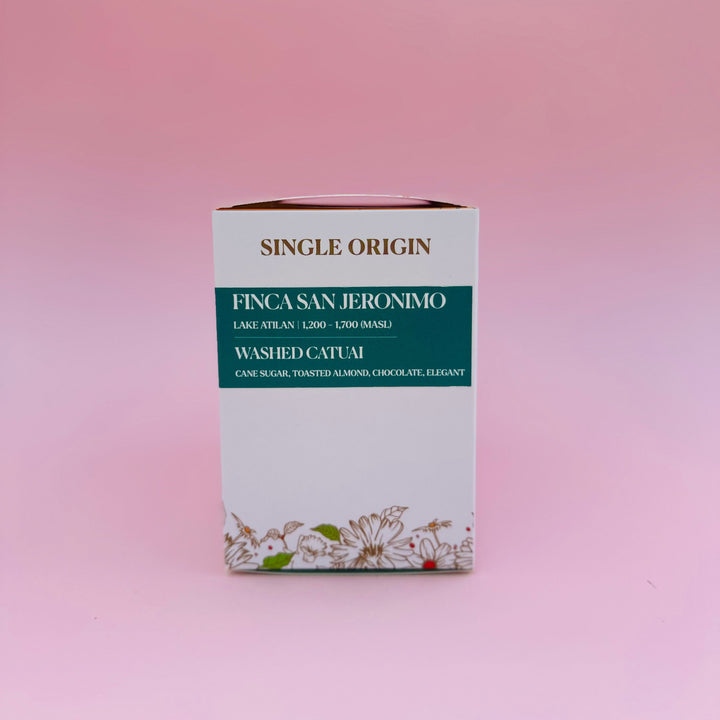 A single-origin Heady Cup Coffee Roasters box labeled FINCAS SAN JERONIMO, with washed catuai text and floral artwork near the bottom, standing upright on a soft pink background.