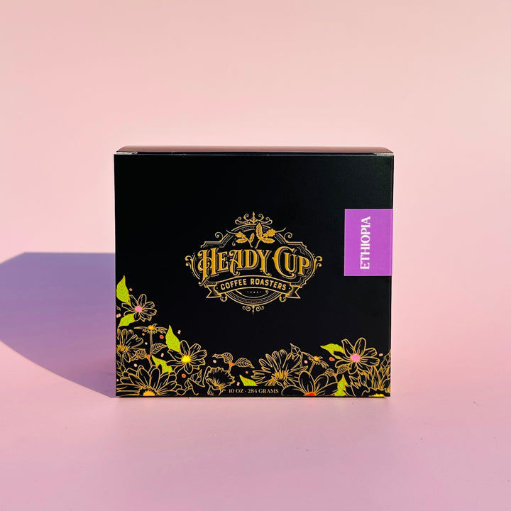 A black Heady Cup Coffee Roasters Zaza Collection box of Ethiopia Coffee. Label is purple and box is against a pink background. 