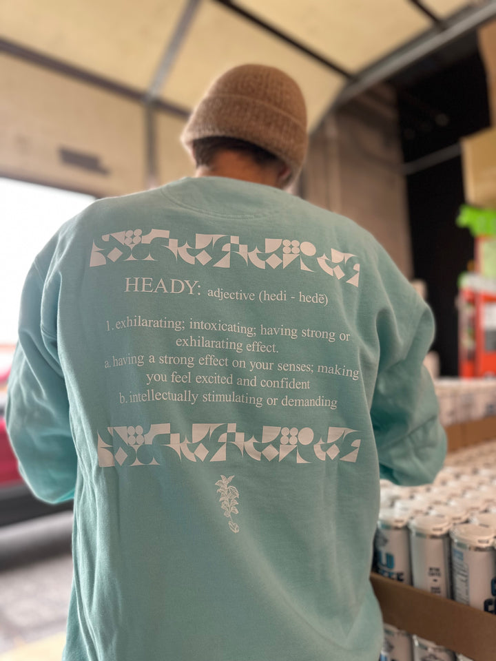 Kurtis wearing a Heady Cup Coffee Roasters definition sweatshirt. Back of sweatshirt is photographed. 