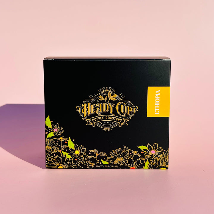 A black Heady Cup Coffee Roasters Zaza Collection box of Ethiopia Coffee. Label is yellow and box is against a pink background. 