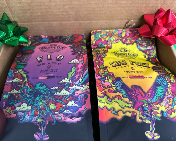 A picture of two colorful Heady Cup Coffee Roasters bags in a  two blend gift box