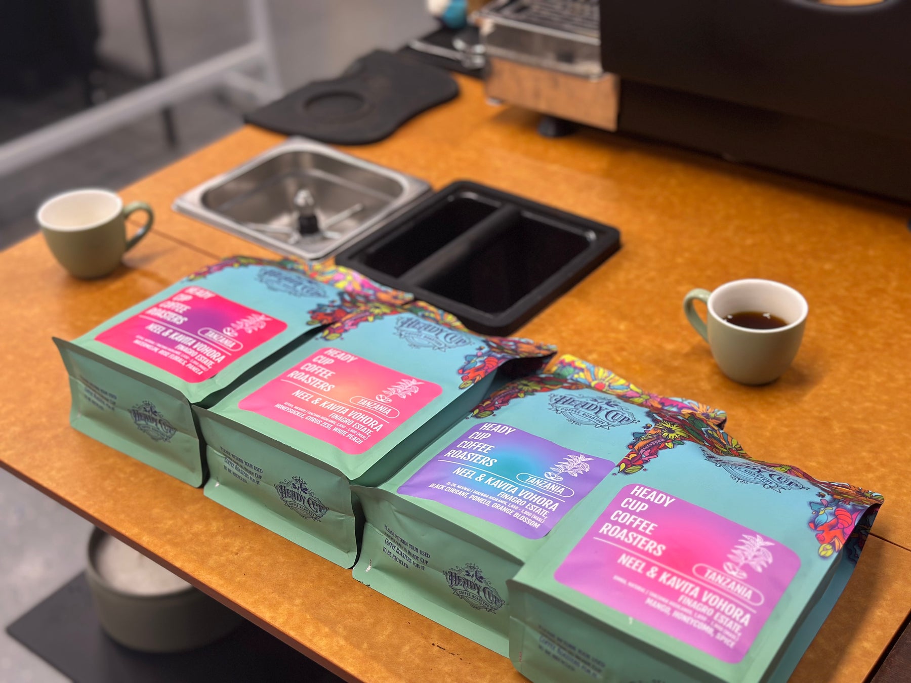 Coffee packages on a counter with a cup of coffee nearby