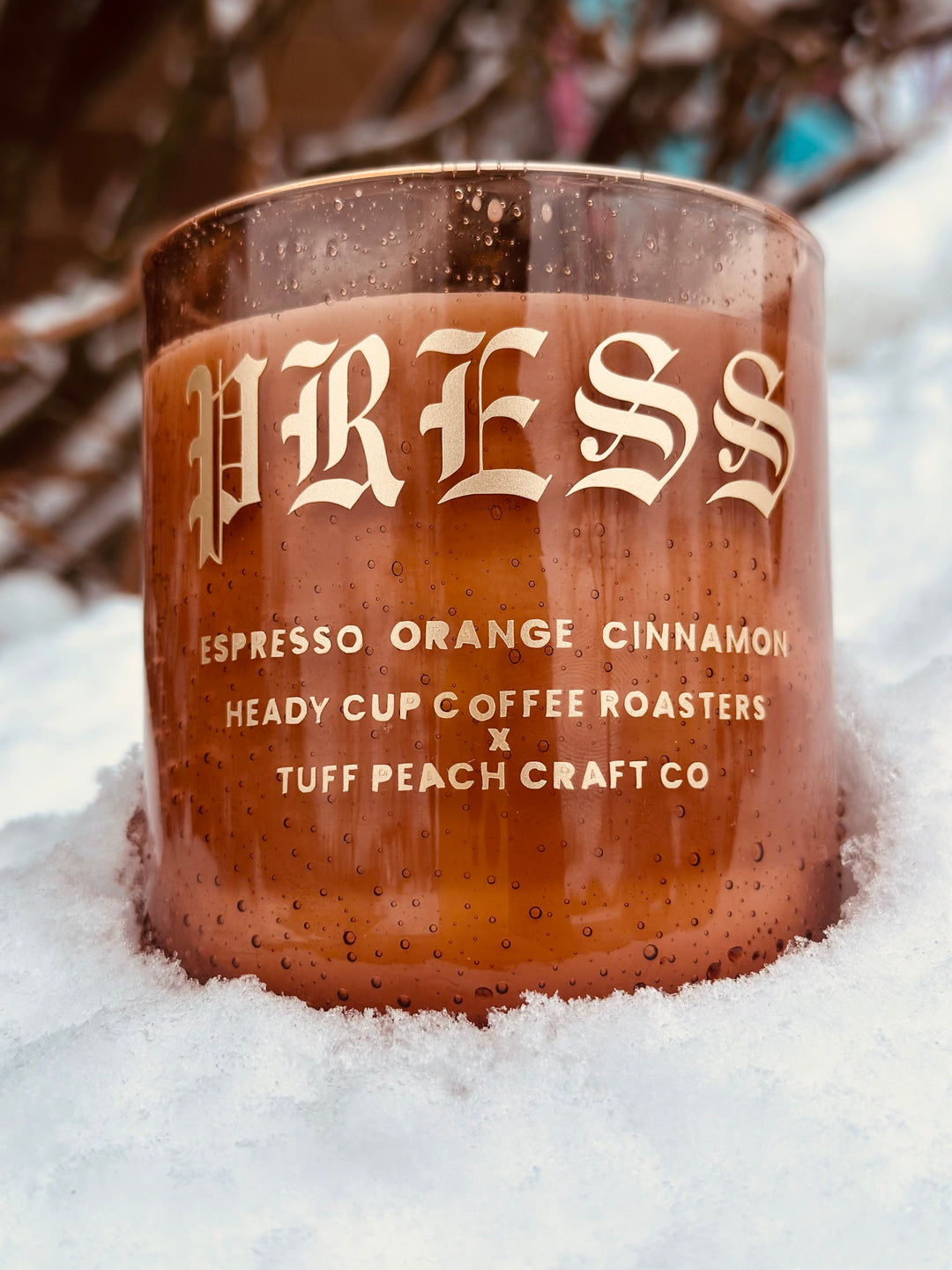 Picture of a Heady Cup Coffee Roasters x Tuff Peach Craft Co. Candle on a grey background. Espresso, Orange and Cinnamon label by Ninety Two Creative. 