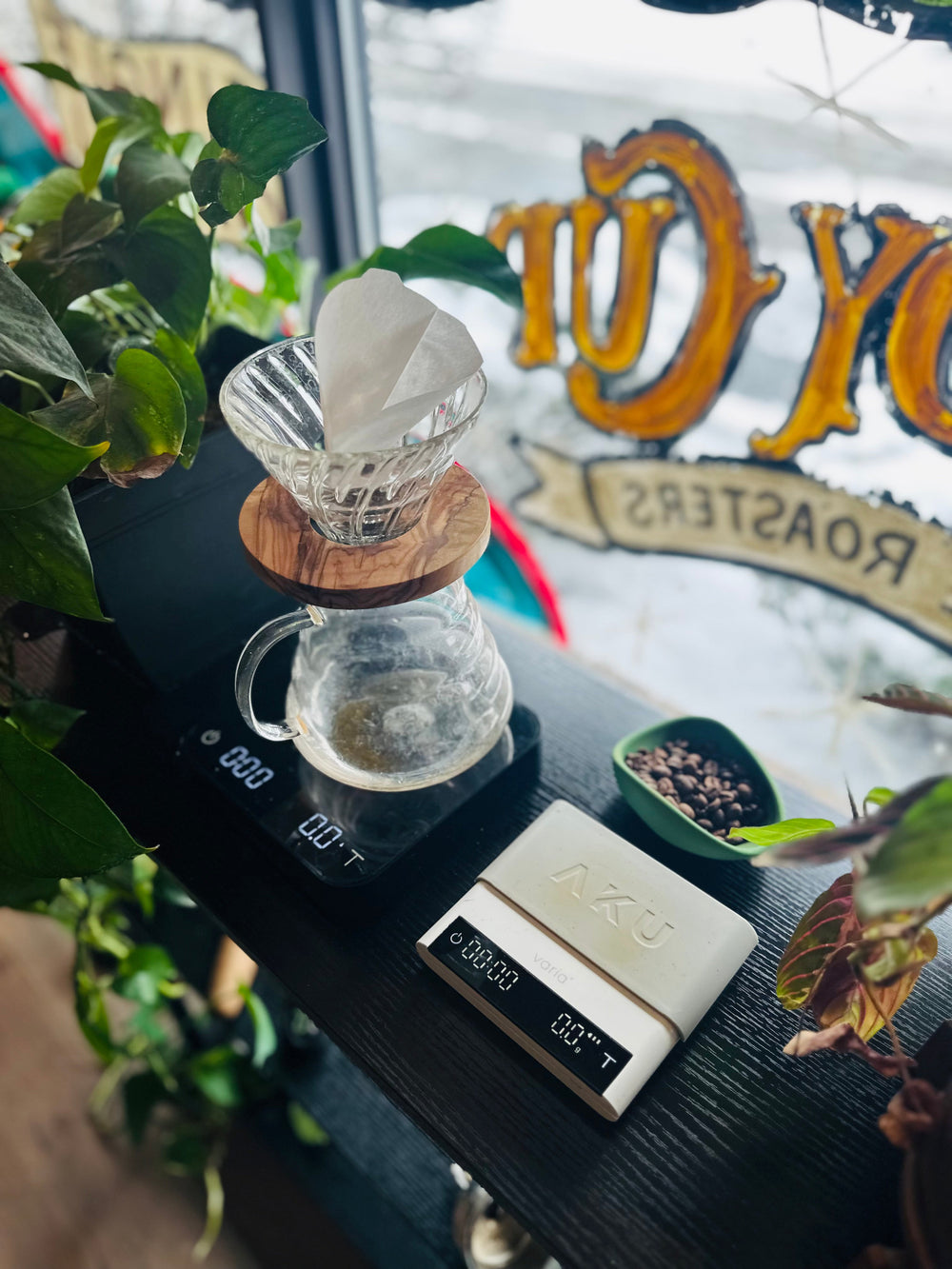 Pour-Over Coffee brewing setup with a glass carafe and filter on a digital scale, with a Heady Cup Coffee Roasters banner in the background.