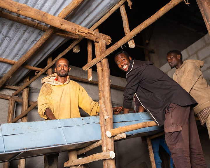 Ethiopian coffee workers in a coffee mill tending to recently harvested Sidama coffee cherries. 