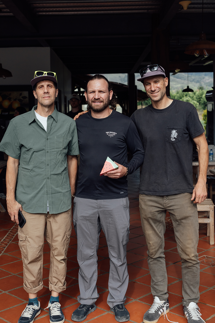 Kurtis Kearby, Sebastian Ramirez, and Michael Kivland standing while Sebastian holds a box of Heady Cup Coffee Roasters' coffee that Sebastian grew. 